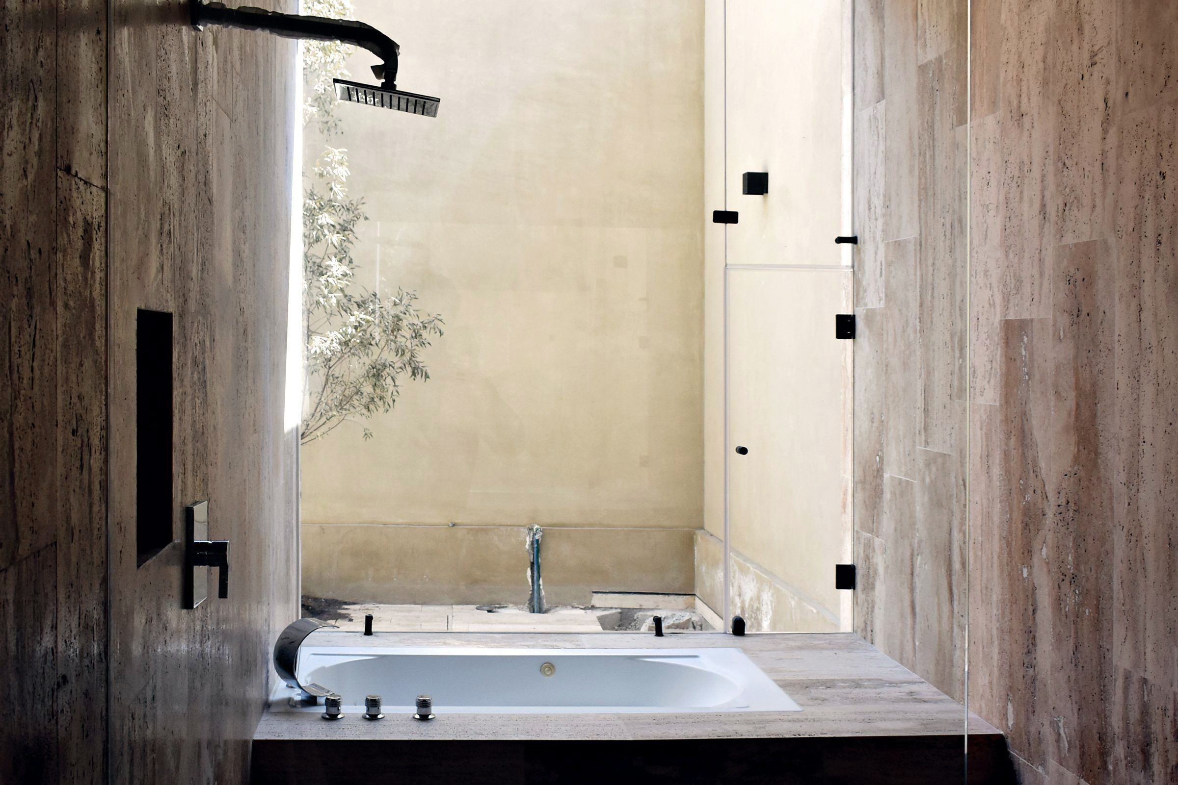 Baño con tina y travertino